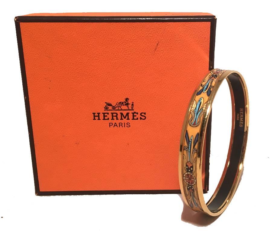 STUNNING HERMES Enamel bangle bracelet in excellent condition.  Unique dreamcatcher print over a golden yellow background surrounded by gold hardware and a black backing.  Stamped Hermes, made in Austria 