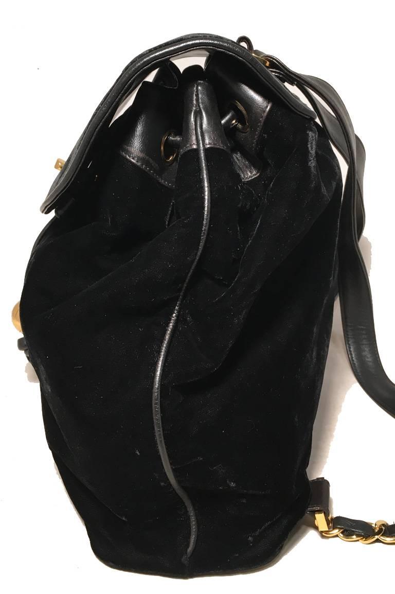 STUNNING Chanel black velvet backpack in excellent vintage condition.  Black velvet body trimmed with black leather and gold hardware.  Signature woven chain and leather shoulder straps on back.  Embroidered CC logo along front side.  Golden CC logo