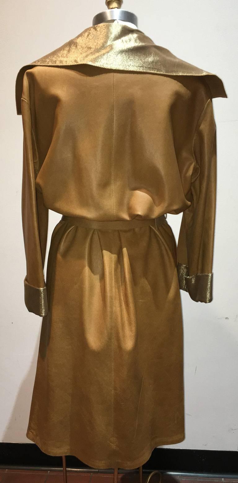`GORGEOUS Chanel tan leather and gold lame coat in excellent condition. Soft tan leather exterior trimmed with a matching leather belt and gold lame style lining. Long sleeve style with wide lapel. Belted front closure. 2 slit pockets. gold