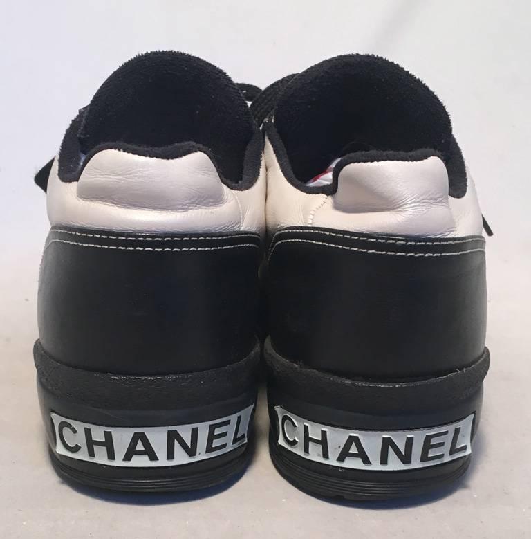 AMAZING Vintage Chanel black and white leather sneakers in very good condition.  Black and white leather upper with white contrast stitching throughout and the signature CC logo upon both top toes.  Tan leather interior and insole. Black rubber sole