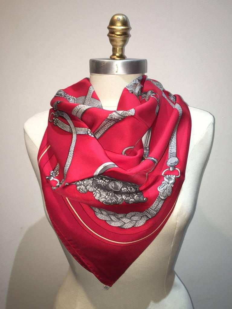 Beautiful Vintage Hermes red silk Gaucho scarf in very good condition.  Original silk screen design c1978 by Caty Latham features various horse dressings and bridal hardware over a red background.  100% silk, hand rolled hem, made in france.