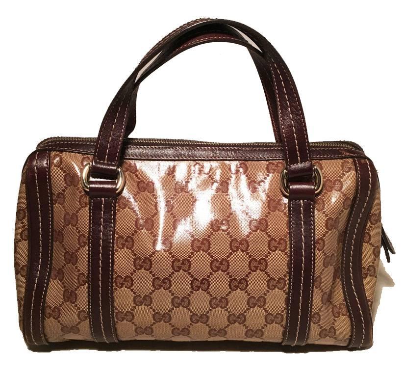 Beautiful Gucci monogram bowler handbag in very good condition.  Coated monogram canvas exterior trimmed with brown leather and silver hardware.  Double brown leather handles and a unique silver bow detail along front side with Gucci emblem charm