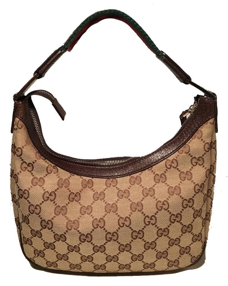 RARE Gucci monogram mini shoulder bag in excellent condition.  Monogram canvas exterior trimmed with silver hardware, striped canvas strap, and brown leather piping around edges.  Red and green striped woven handle/shoulder strap.  Top zipper