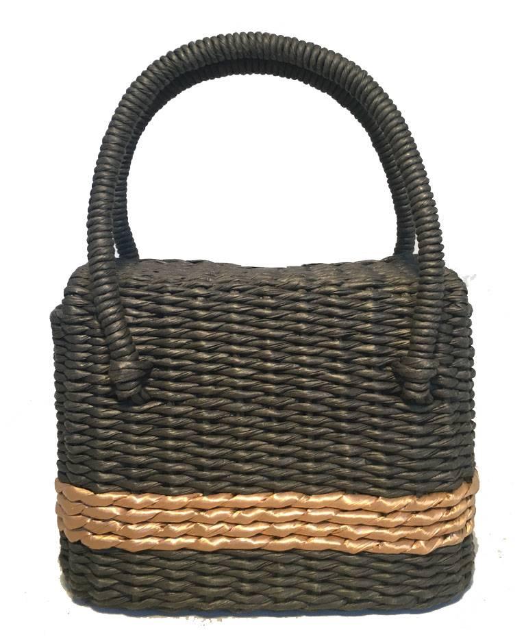 Limited Edition Chanel charcoal wicker basket bag in excellent condition.  Woven charcoal grey rattan wicker exterior with a tan stripe surrounding.  2 corded wicker handles and matte silver hardware closure.  Pinch latch closure opens via Double