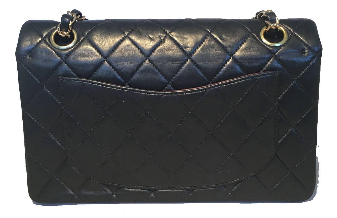 TIMELESS Chanel black 9inch 2.55 double flap classic in very good condition.  Quilted lambskin leather exterior trimmed with gold hardware and a woven chain and leather shoulder strap.  Front CC logo twist closure opens via double flap to a maroon