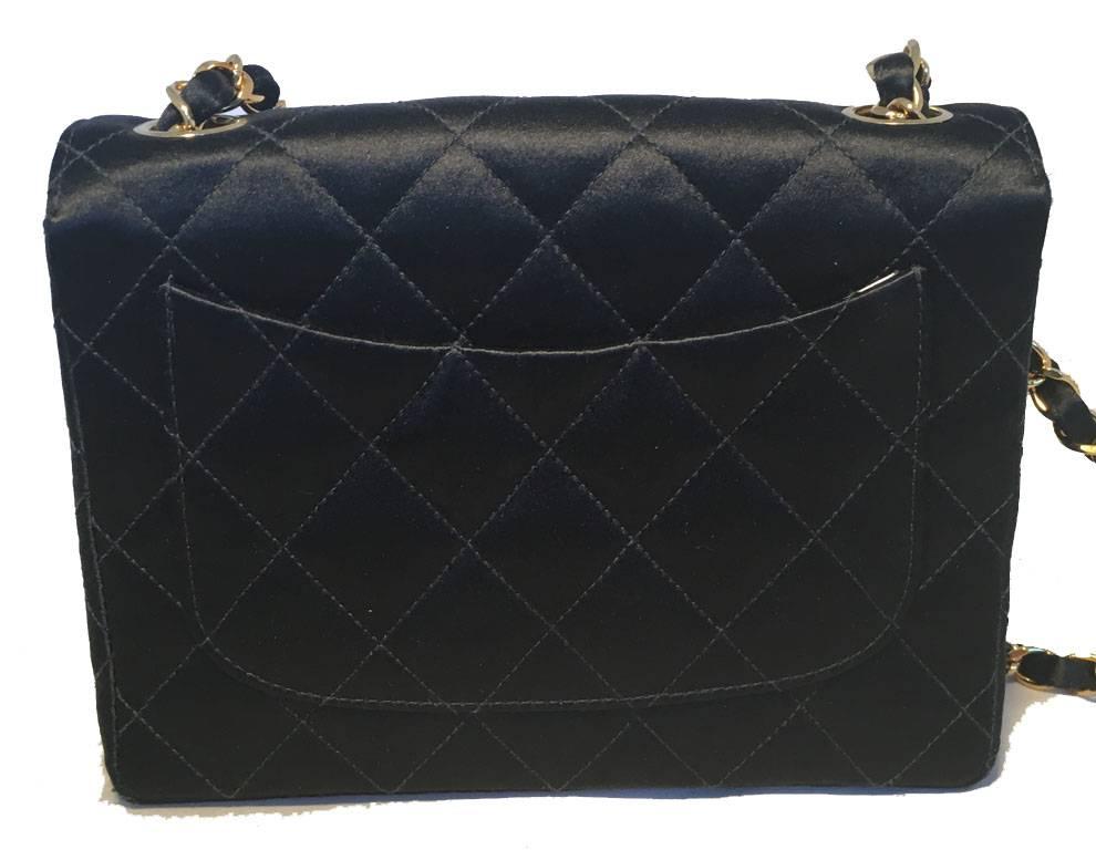 BEAUTIFUL Chanel black satin mini classic flap in excellent vintage condition.  Quilted black satin exterior trimmed with gold hardware and woven chain and satin shoulder strap.  Front CC logo twist closure opens to a gold leather lined interior
