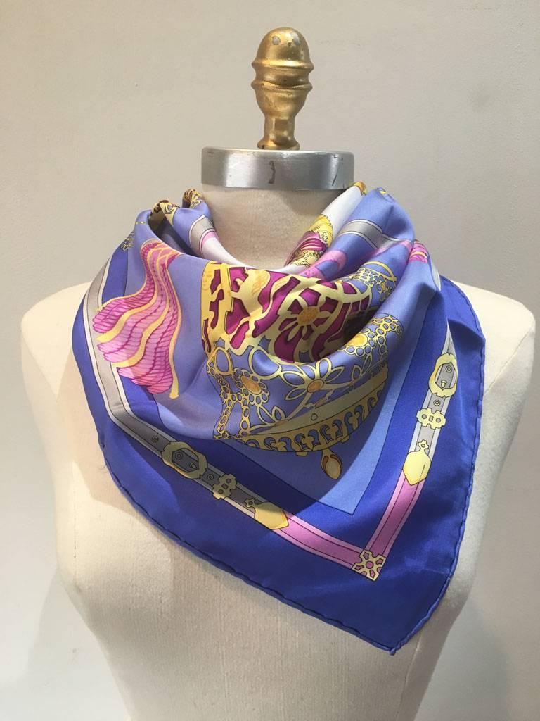 Gorgeous vintage Hermes les Muserolles silk scarf in excellent condition. Original silk screen design c1986 by Christiane Vauzelles features whimsical silver bridle dressings for any royal knight over a light blue background surrounded by a lilac
