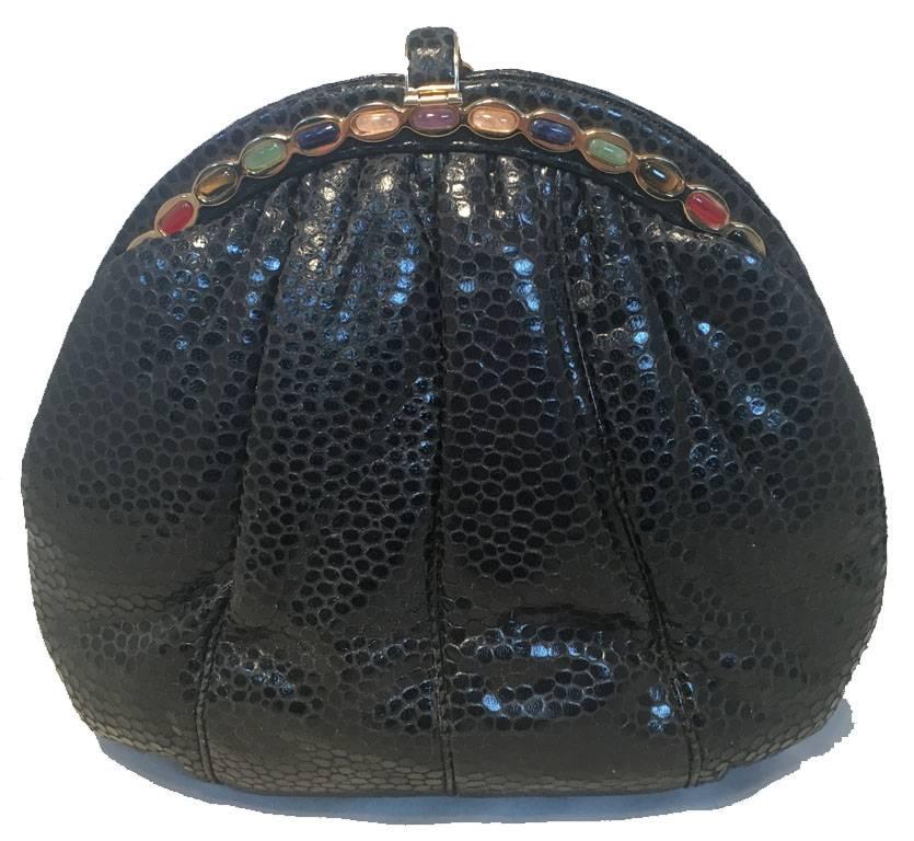 RARE Judith Leiber black lizard leather clutch in excellent vintage condition.  Black lizard leather exterior trimmed with gold hardware and multicolor stone details along top edge.  Lifting top closure opens to a black nylon lined interior that