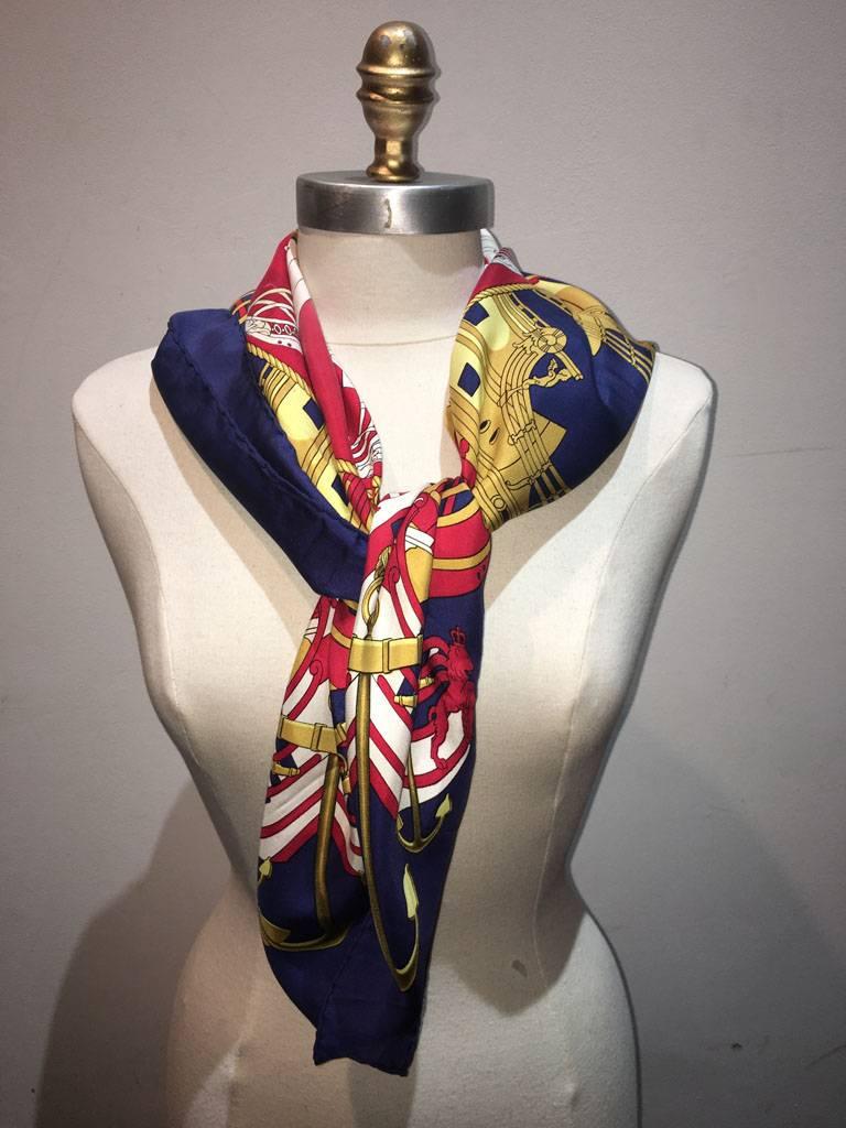 BEAUTIFUL Vintage Hermes Proues silk scarf in navy in very good condition.  Original silk screen design c1973 by Philippe Ledoux features a symmetrical nautical theme print in red and gold over a navy blue background.  100% silk, hand rolled hem,
