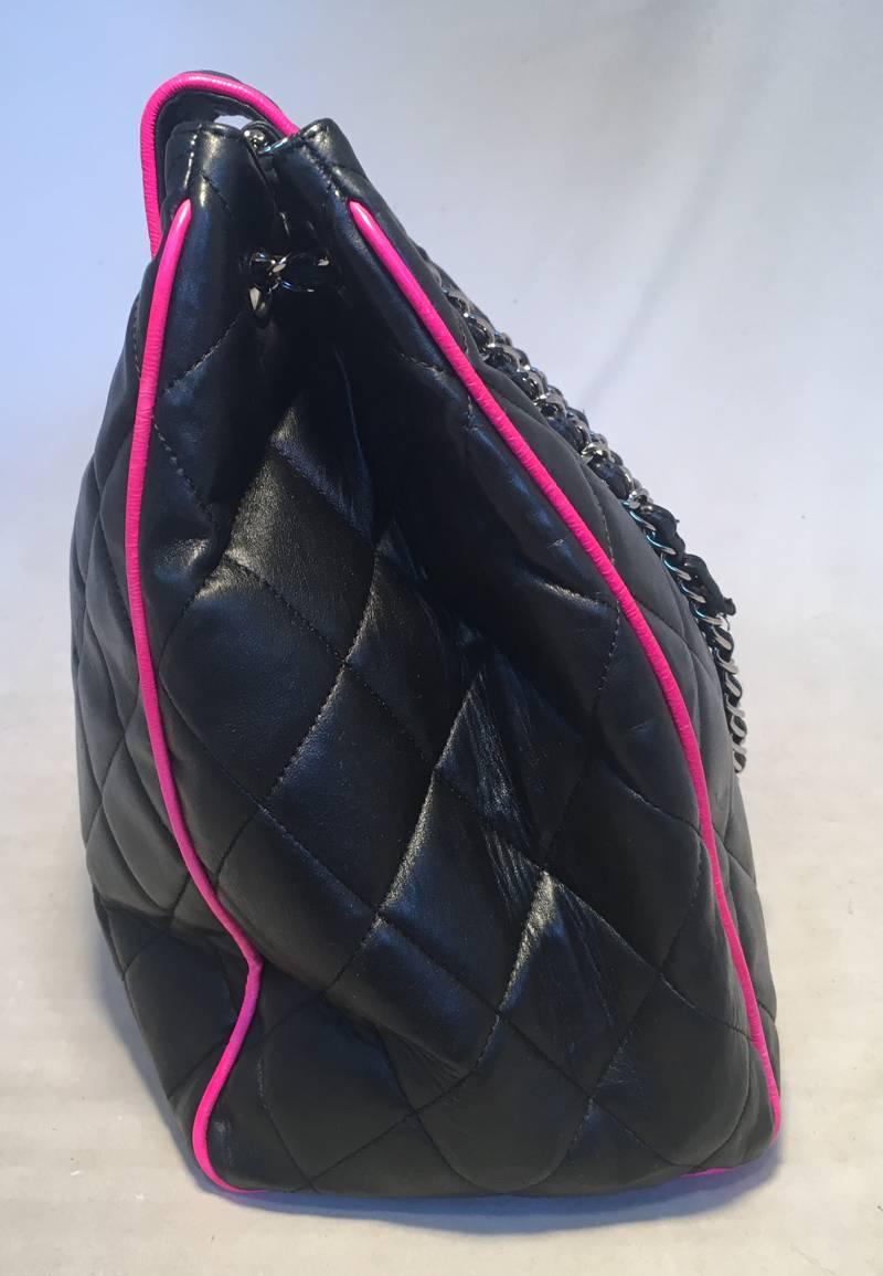 GORGEOUS Chanel black leather with hot pink piping trim around the exterior.  Silver hardware and woven chain and leather shoulder straps.  Front CC lifting logo closure opens to a black silk lined interior that holds ample storage space, 2 slit and