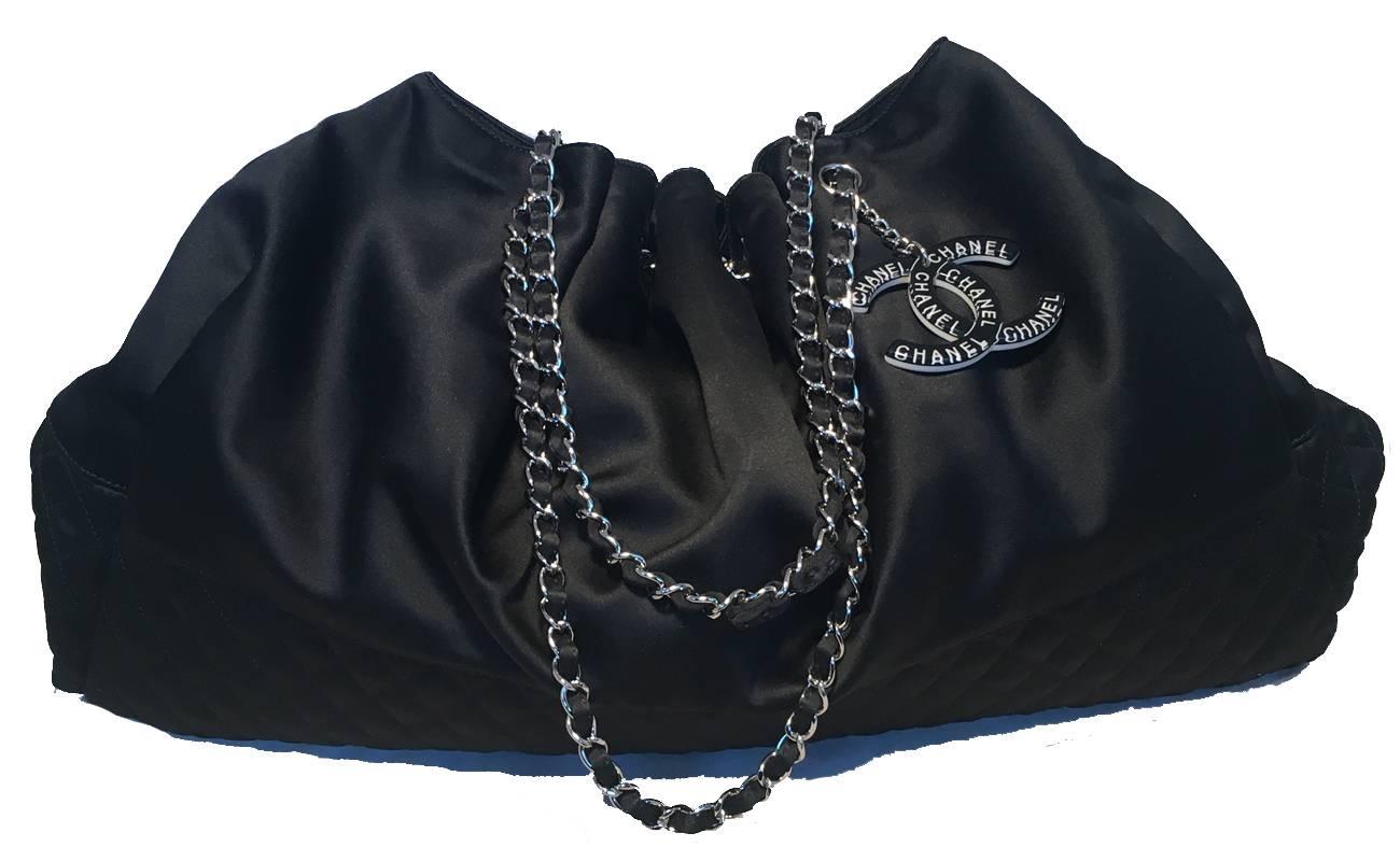 GORGEOUS Chanel black silk shoulder bag in excellent condition.  Black silk exterior trimmed with silver hardware and a black and white resin CC logo keychain detail.  Top drawstring style closure opens to a grey silk lined interior that holds 1