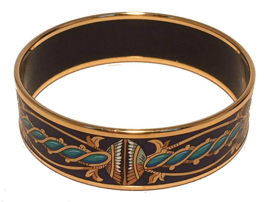 BEAUTIFUL Hermes enamel print bangle bracelet in very excellent.  Navy blue background with gold, teal, and blue print throughout trimmed with gold hardware and black inside.  No stains, scuffs or chips.  Signed hermes, Made in Austria stamped