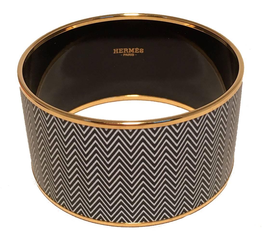 gorgeous Hermes zig zag enamel bangle bracelet in excellent condition.  Black and white zig zag enamel print trimmed with gold hardware.  No scuffs or major scratches.  Made in France stamped P.  Original bracelet box and duster included. 