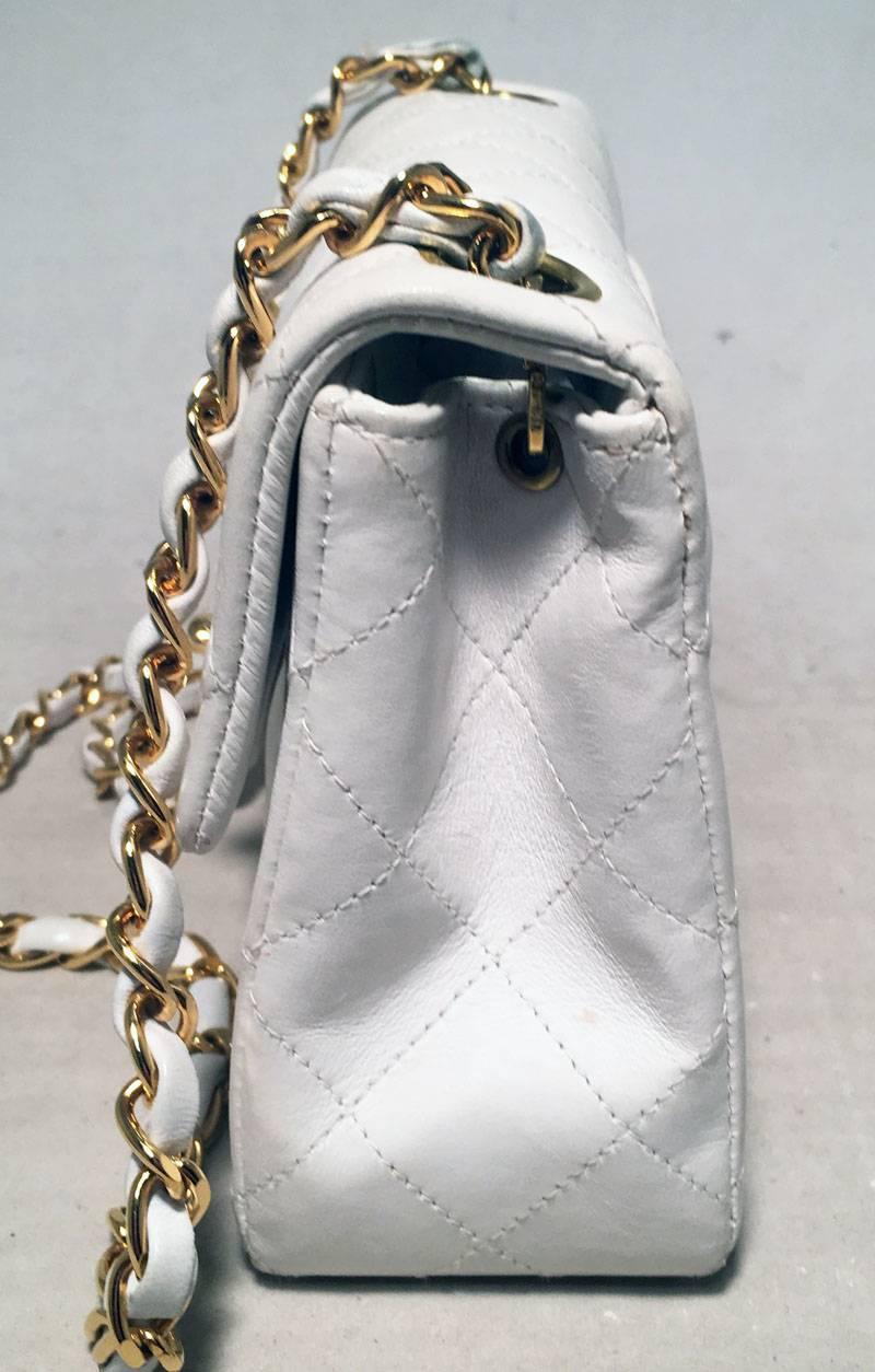 Chanel White Quilted Leather Mini Classic Flap Shoulder Bag in excellent condition.  Quilted white lambskin leather exterior trimmed with gold hardware.  Signature twisting CC logo front closure opens to a white leather lined interior that holds 1