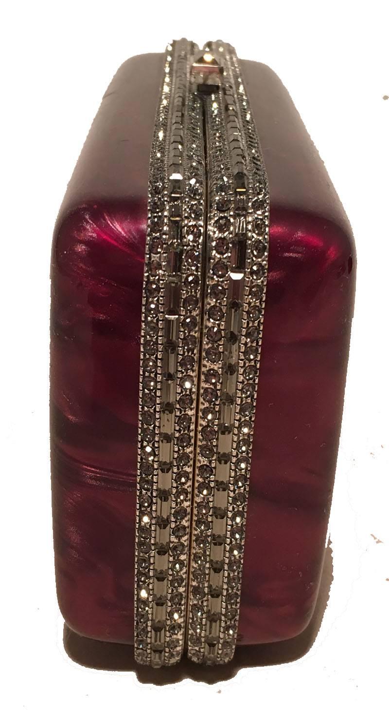 STUNNING Judith Leiber Maroon Pearlized Box Clutch with Crystals in excellent condition.  Maroon pearlized box clutch with gunmetal hardware and crystals surrounding.  Top lift closure opens to a silver leather interior that holds an attached chain