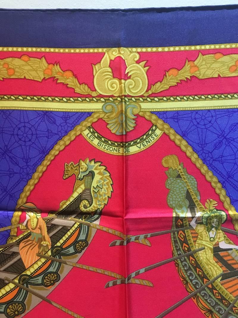 GORGEOUS Hermes les bisson de venise silk scarf in excellent vintage condition.  Original silk screen design c1988 by Annie Faivre features 4 various golden row boats over a soft red and royal blue patterned background.  4 golden 