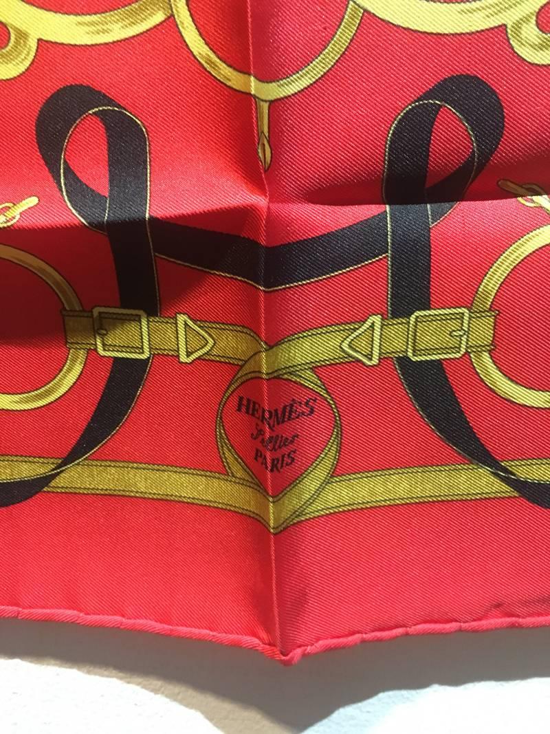 Amazing Hermes Vintage Eperon d'Or Silk Pocket Square Handkerchief in very good condition.  Original silk screen design c1974 by Henri d'Origny features an array of horse bridles, belts and buckles in black and gold over a red background. 100% silk,