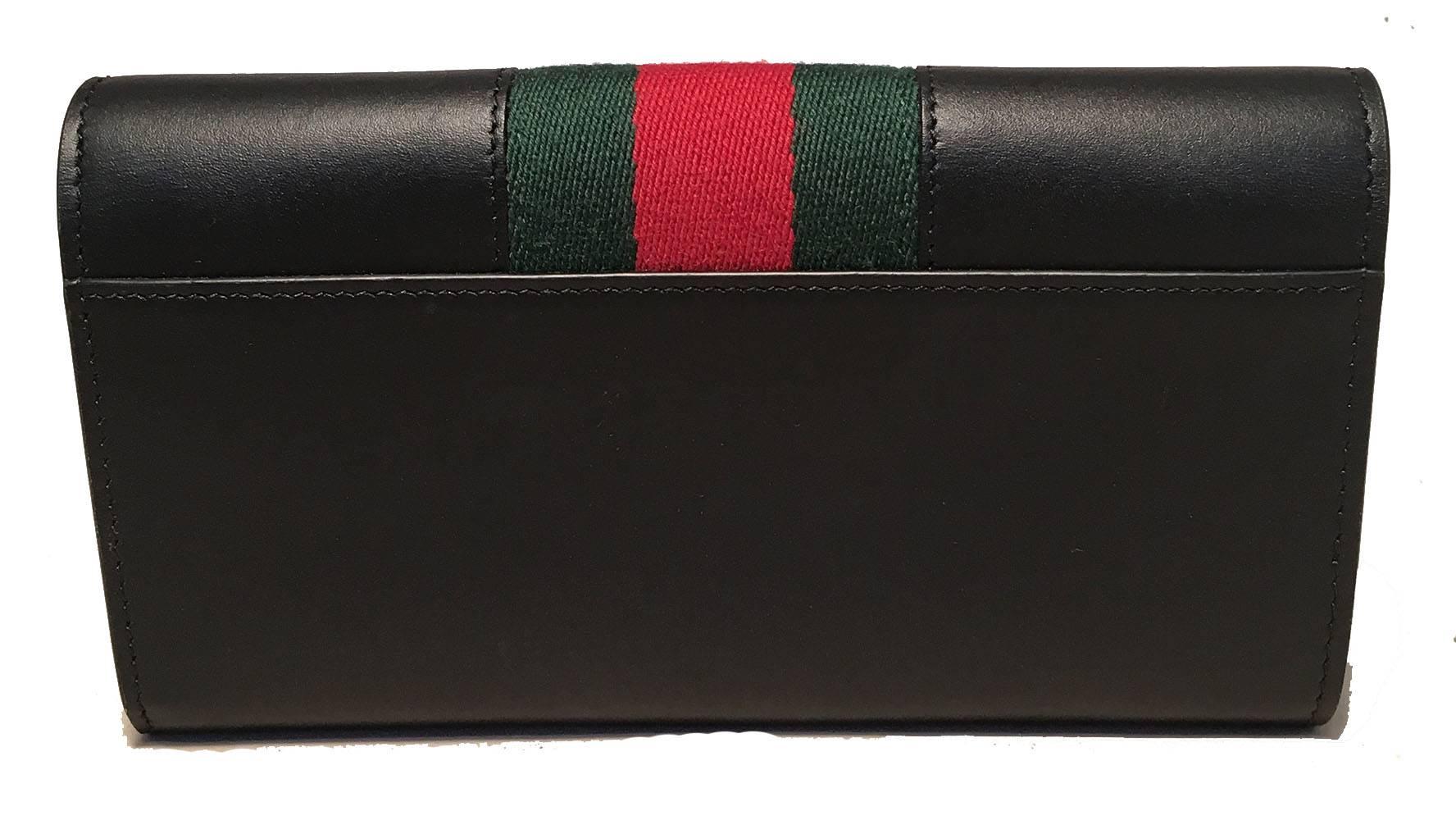 TIMELESS Gucci long sylvie wallet in excellent condition.  Navy blue leather exterior trimmed with signature red and green gucci canvas stripes along front with a gold buckle detail along top front flap. Snap flap closure opens to a navy leather