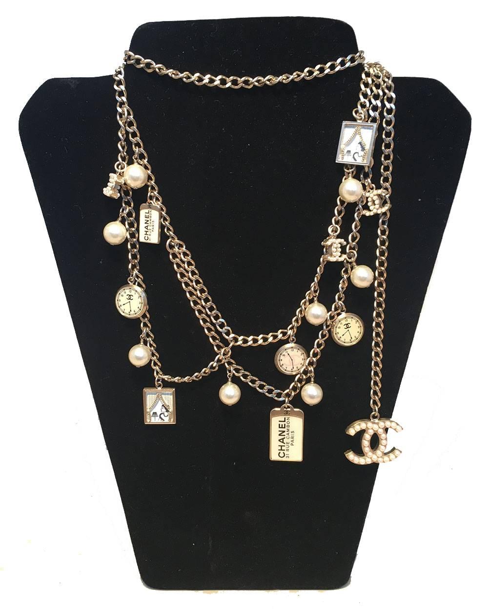 AMAZING Chanel silver charm belt necklace in excellent condition.  Silver chain with 8 drop pearls, 3 mini CC pearl logo charms, 3 clock charms, 2 square woman in window photo charms, and 2 Chanel rue cambon dog tag charms (one small, one large).
