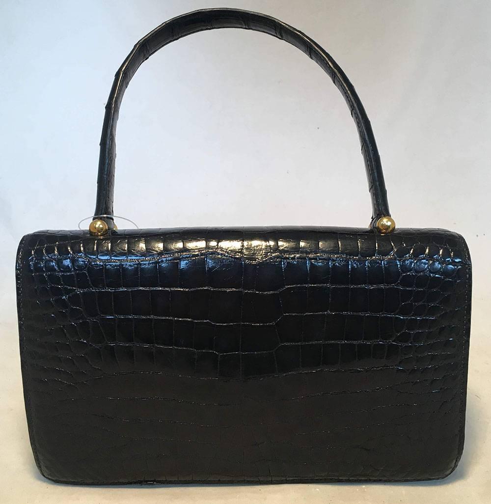 RARE Vintage Hermes black alligator handbag in excellent condition.  Black alligator exterior trimmed with a gold spring latch closure. Single flap style closure opens to a black soft leather lined interior that holds 3 slit, 1 lipstick, and 1
