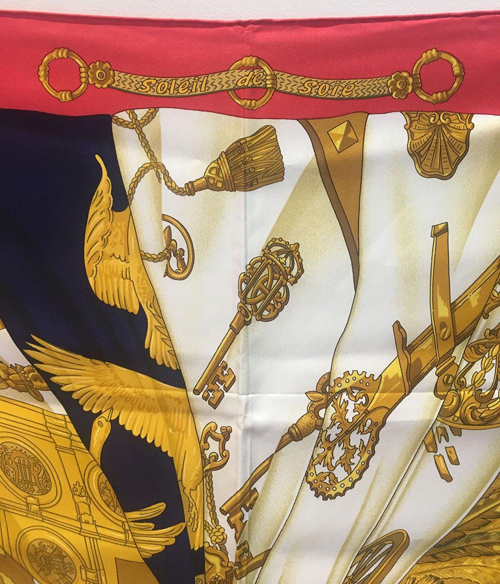 GORGEOUS Hermes Vintage Soleil de Soie Silk Scarf in Navy and Red in excellent condition. Original silk screen design by caty Latham c1995 features an artistic broken mirror/puzzle design with pieces in gold and white surrounding a navy centered bow
