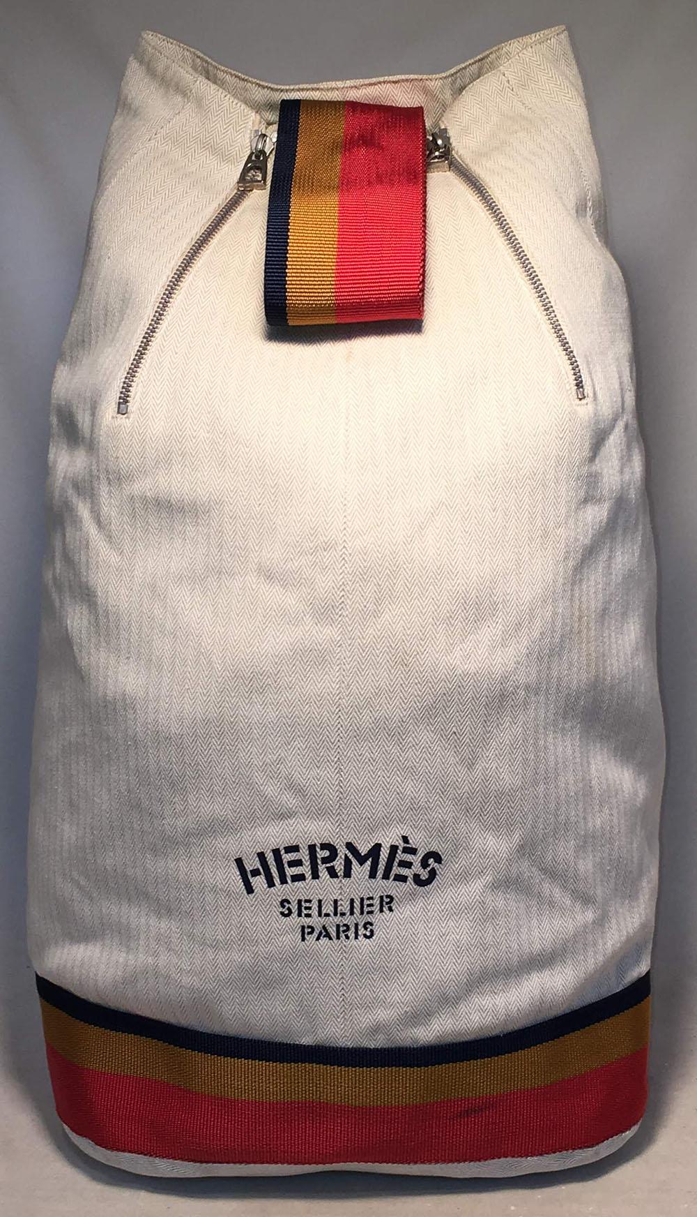 RARE Hermes Herringbone Canvas Sling Backpack Shoulder Bag in very good condition. Signature herringbone canvas exterior trimmed with woven orange, gold and navy striped canvas along bottom and shoulder strap. Double pleated zippers along top and