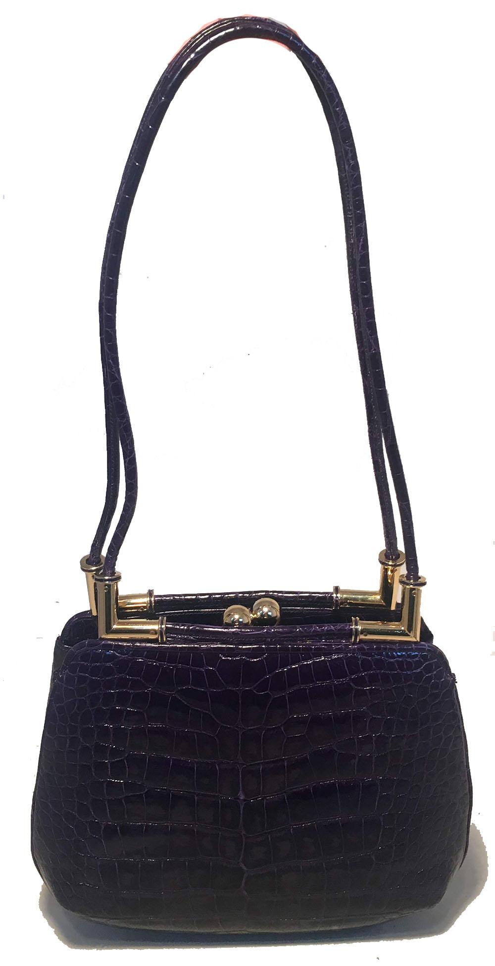 STUNNING Judith Leiber Dark Purple Alligator Shoulder Bag in excellent condition. Dark purple alligator exterior trimmed with gold hardware and double shoulder straps. 2 exterior side slit pockets. Top kiss lock closure opens to a purple leather