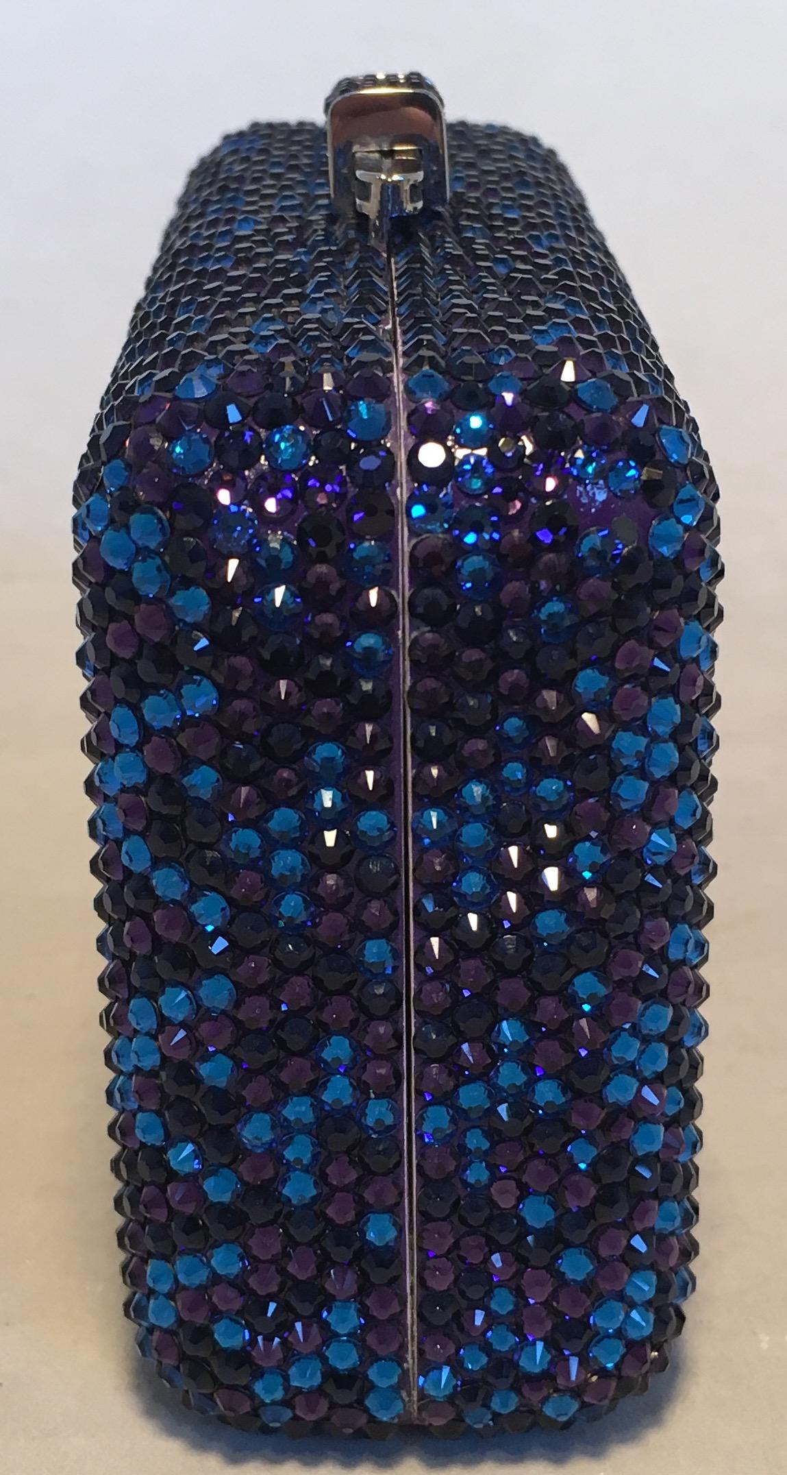 Beautiful Judith Leiber Blue and Purple Swarovski Crystal Minaudiere Evening Bag Clutch in excellent condition. Blue and purple crystal exterior trimmed with silver hardware and a top sliding latch closure. Silver leather interior with removable