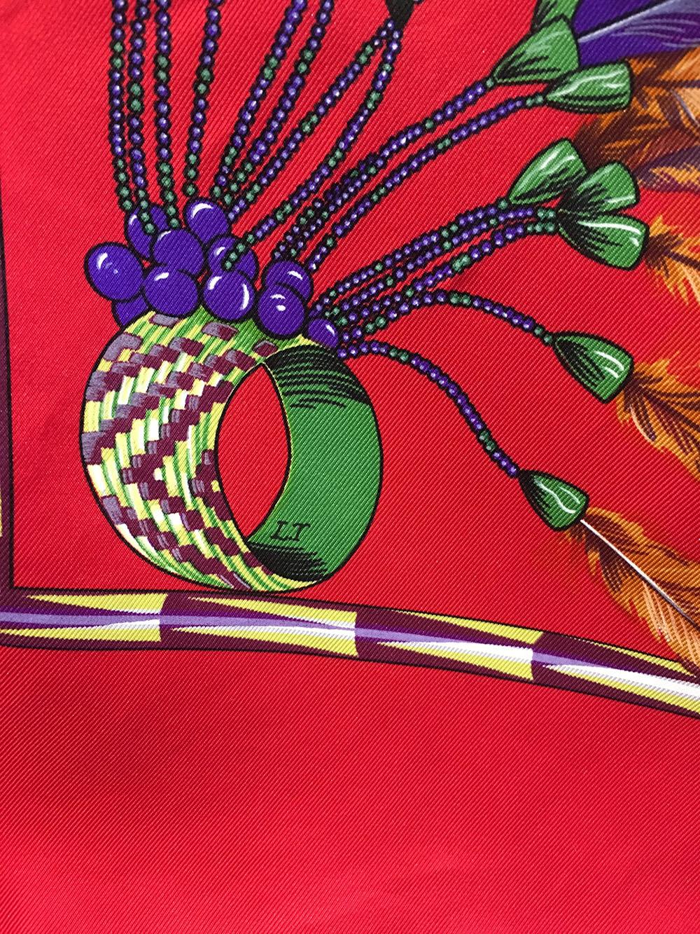 Authentic Hermes Brazil Scarf c1988 in excellent condition. Original silk screen design by Laurence Bourthoumieux features a multi colored floral headdress design native to the culture of Brazil over a red background and surrounded by various