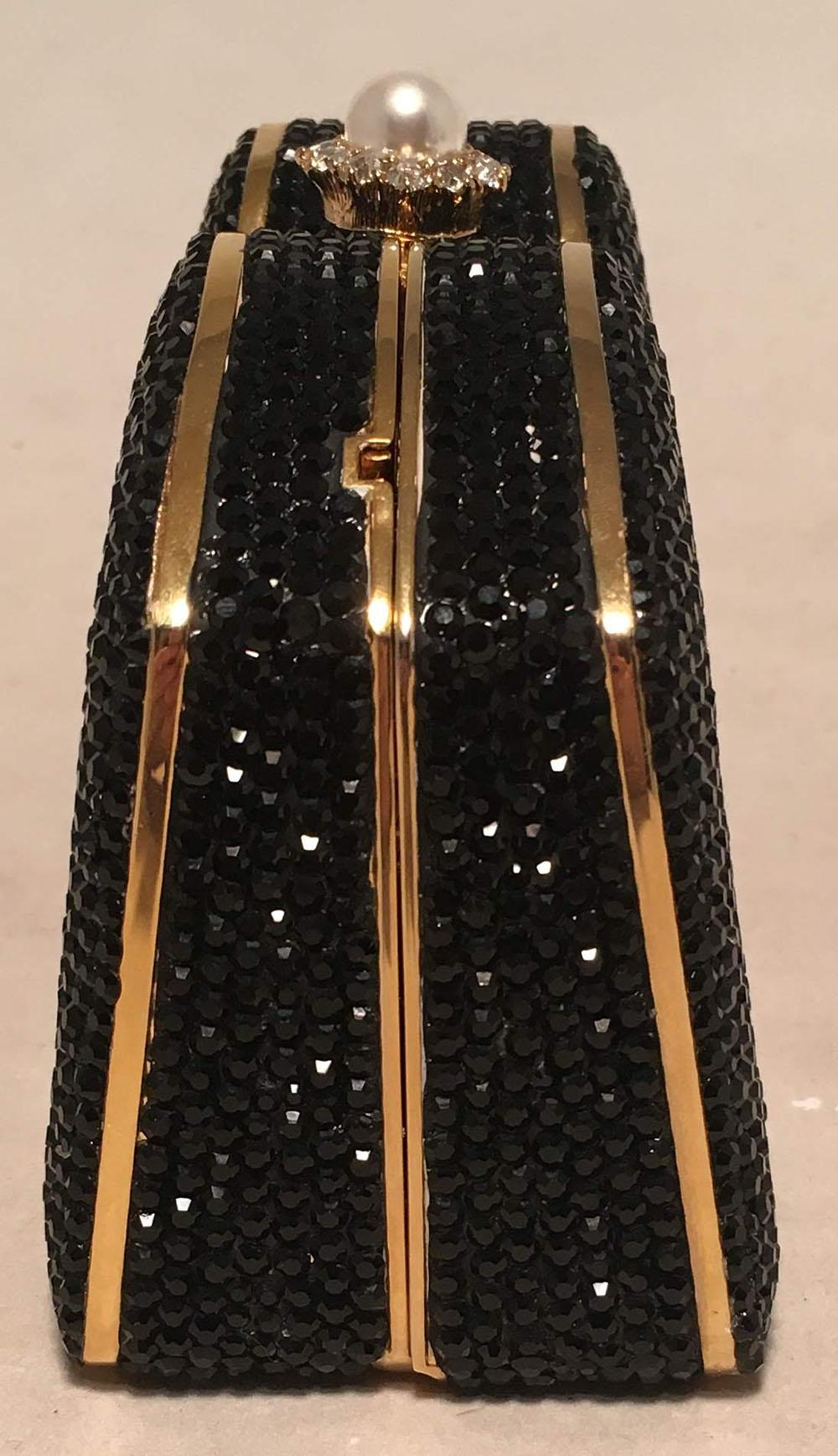 BEAUTIFUL Judith Leiber Black Swarovski Crystal Minaudiere Evening Bag Clutch in excellent condition. Black swarovski crystal exterior trimmed with gold hardware and pearl top push button closure. Gold leather lined interior that holds a gold chain