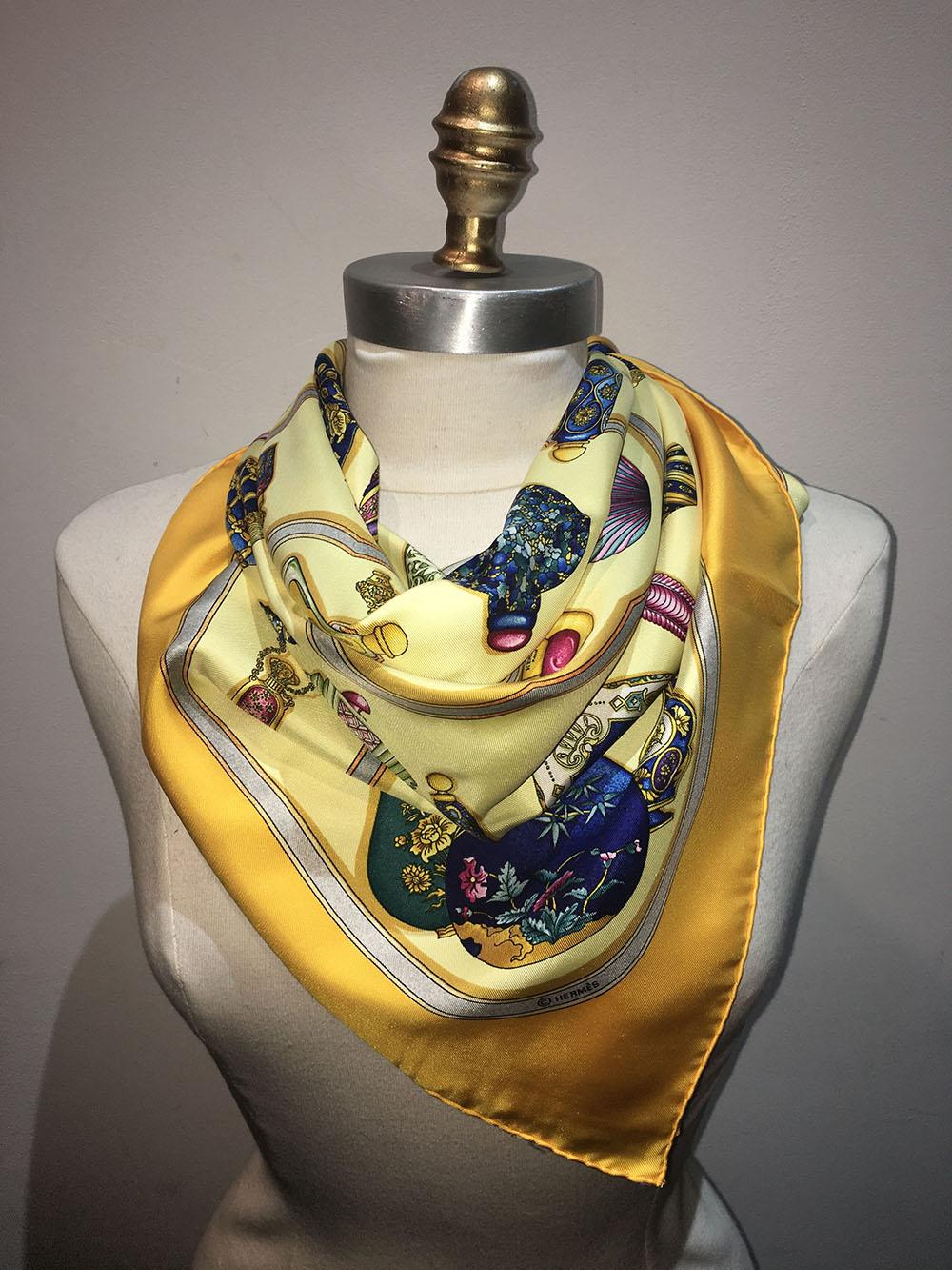 AUTHENTIC HERMES silk Qu'Import le Flacon silk scarf in excellent condition. Original silk screen design c1988 by Catherine Baschet features an array of perfume bottles over a pale yellow background surrounded by a dark yellow border. This piece is