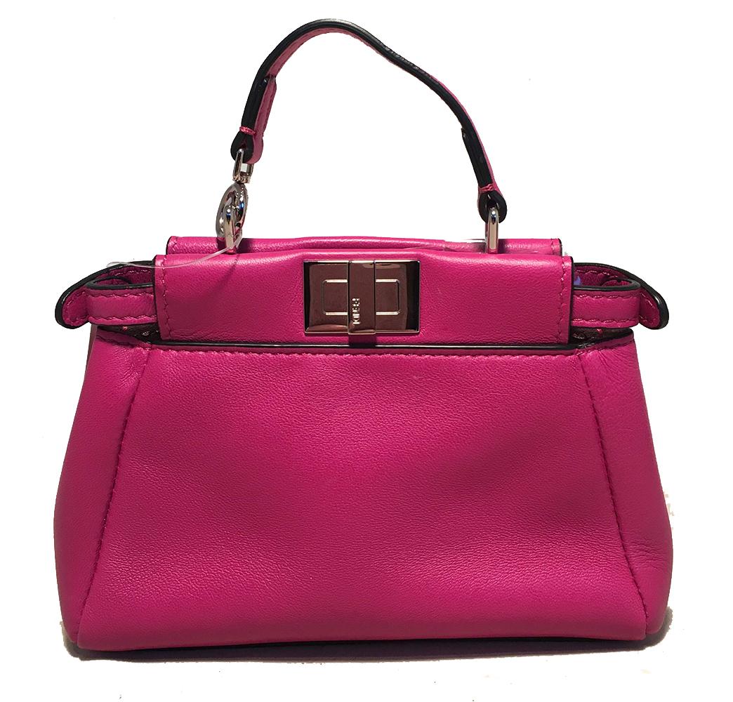 ADORABLE Fendi Micro peekaboo bag in excellent condition. Mini peekaboo bag style in fuchsia pink leather with silver hardware. Top twist and snap closures open to a dark grey suede lined interior that holds 2 side slit pocket and an additional