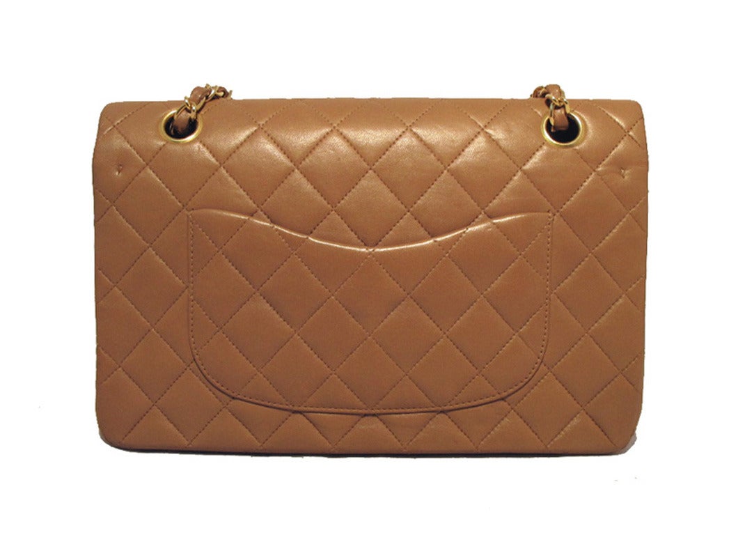 Authentic Chanel cocoa lambskin 10inch double flap classic in excellent condition. Cocoa quilted lambskin exterior trimmed with shining gold hardware and the signature twisting CC closure. The double flap style opening reveals a matching tan leather