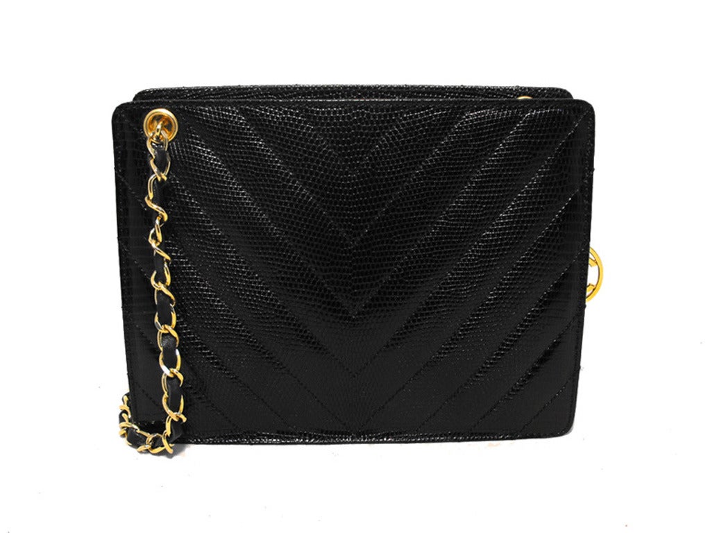 GORGEOUS CHANEL black lizard shoulder bag in excellent condition.  Black lizard leather exterior quilted in a chevron pattern and trimmed with shining gold hardware.  Woven chain and leather shoulder strap and signature Chanel CC logo charm upon top