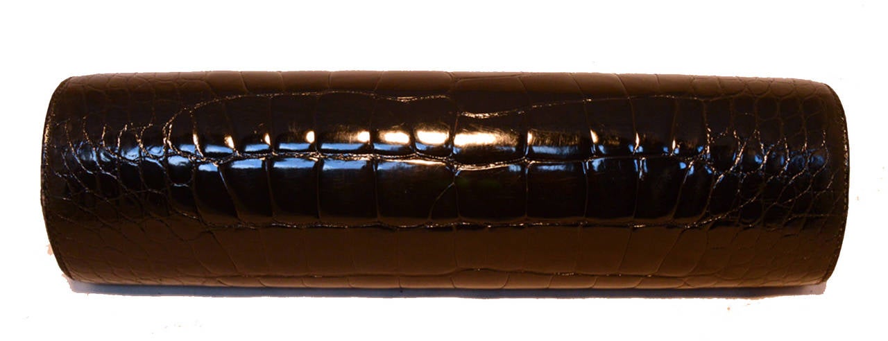 Rare Barry Kieselstein-Cord black alligator clutch in excellent condition.  Black alligator exterior trimmed with matte gold hardware along and a unique sliding side latch closure.  Green suede lined interior holds 1 slit and 1 small zippered side