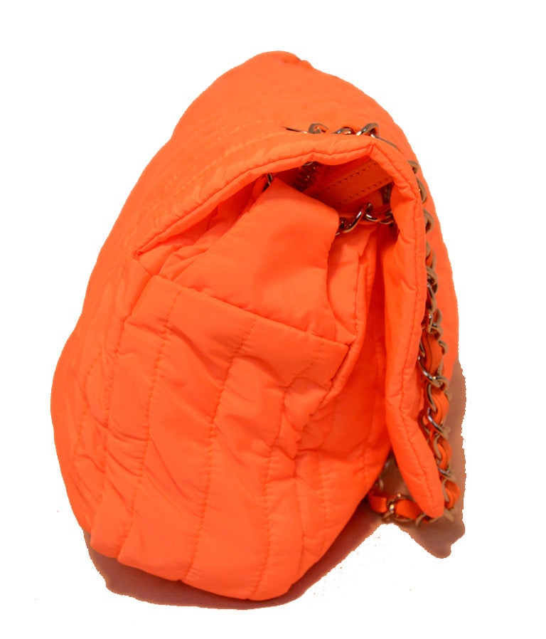 STUNNING CHANEL quilted classic flap in excellent condition.  Neon orange quilted nylon exterior trimmed with shining silver hardware.  Signature twist CC logo closure opens to a matching orange nylon lined interior that holds 1 side zippered