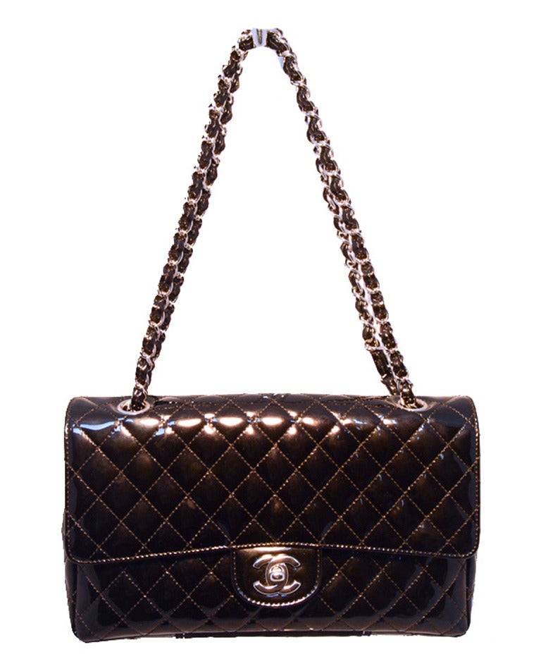 FABULOUS CHANEL black patent leather classic flap shoulder bag in excellent condition.  Black patent leather quilted exterior trimmed with silver hardware.  Signature CC logo twist closure opens to a maroon nylon lined interior that holds 1 slit and