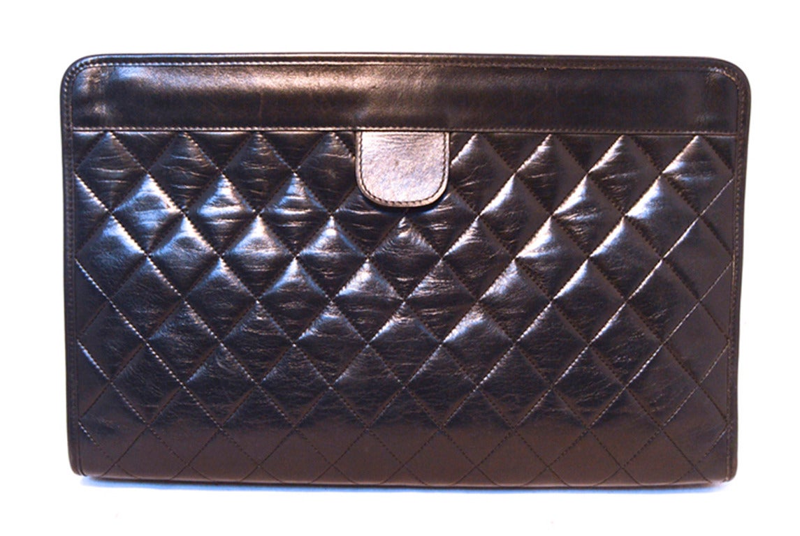 GORGEOUS AUTHENTIC CHANEL black quilted lambskin leather clutch in excellent condition.  Black quilted lambskin leather exterior trimmed with a delicate gold CC logo along the front side.  Hinged pull closure opens to a maroon leather lined interior