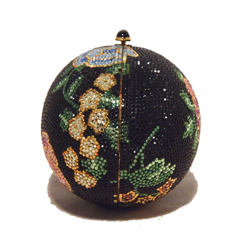STUNNING JUDITH LEIBER swarovski crystal floral faberge egg minaudiere in excellent condition.  Black swarovski crystal exterior with a multi-color floral design throughout the exterior.  Side button closure opens to a gold leather lined interior