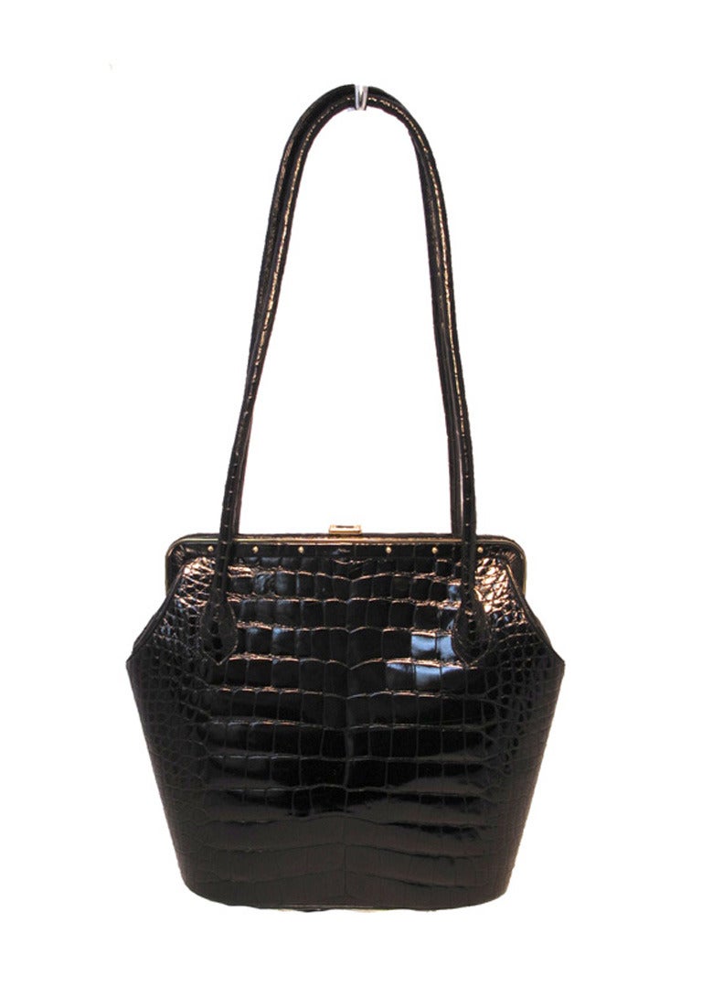 STUNNING Judith Leiber black crocodile shoulder bag in excellent vintage condition.  Black crocodile exterior trimmed with sparkling gold hardware and double sturdy shoulder straps.  Push button closure opens to a black leather lined interior with 1