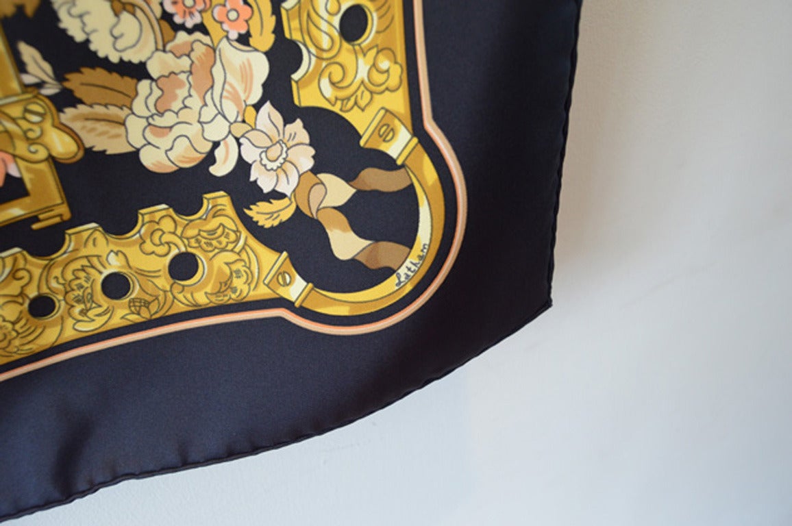 AUTHENTIC HERMES Copeaux silk scarf in excellent condition.  Original silk screen design by Cathy Latham c1998 features a beautiful ribbon design in golds over a black background.  100% silk, hand rolled hem, made in france. original tag attached.