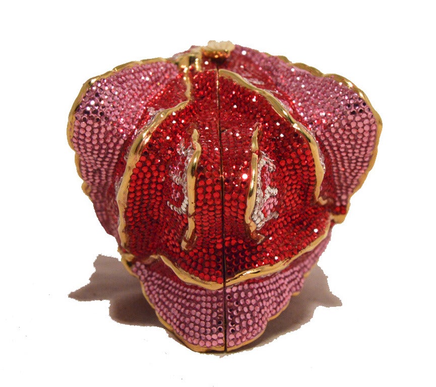 Stunning Judith Leiber Swarovski crystal rose minaudiere in excellent condition.  Pink, red, and clear swarovski crystal exterior in a gorgeous rose blossom design with gold hardware.  Side sliding closure opens to a gold leather lined interior that