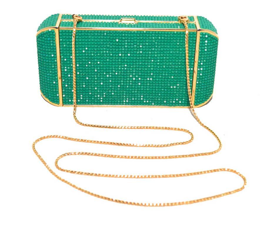 This beautiful Judith Leiber piece is in excellent condition.  The exterior features stunning green and blue Swarovski crystals trimmed with gold hardware.  The push button closure opens to an immaculate gold leather interior that holds a removable