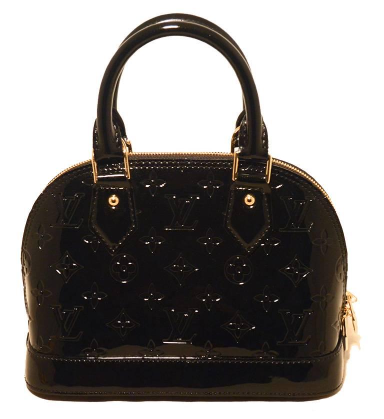 STUNNING LOUIS VUITTON alma bb in NWOT excellent condition.  Black magnetique monogram vernis leather exterior trimmed with gold hardware.  Full double zipper closure opens to a black canvas interior that holds just the right amount of space for