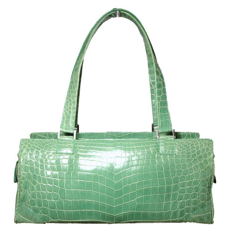STUNNING LAMBERSTON TRUEX green crocodile handbag in excellent condition.  Jade green crocodile leather exterior trimmed with silver hardware.  2 small exterior side pockets with snap flap closures.  Top zippered closure opens to a baby blue suede