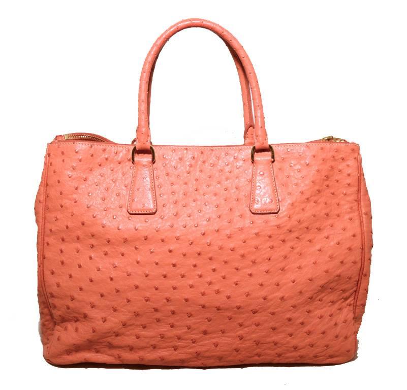 Fabulous Prada Peach coral ostrich leather tote in excellent condition.  Peach ostrich leather trimmed with gold hardware.  Two zippered exterior side compartments to keep belongings secure.  Nude leather lined interior with 3 side slit pockets and