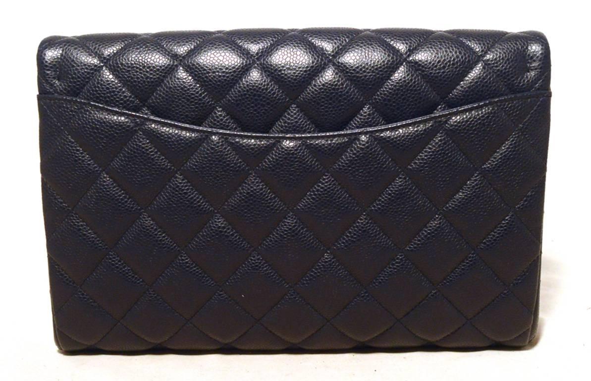 New without tags Chanel navy blue caviar clutch in excellent condition. Deep navy blue quilted caviar leather exterior trimmed with silver hardware.  Single flap snap front closure opens to a navy blue leather lined interior that holds 1 side slit