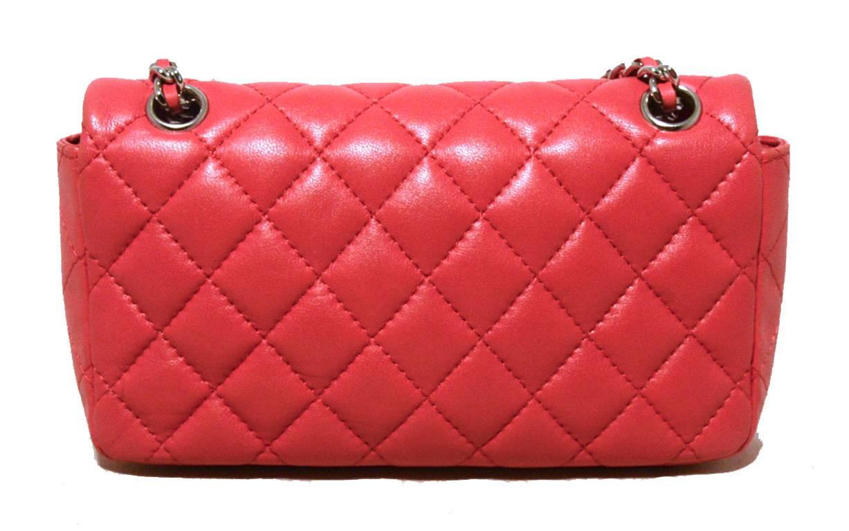 ADORABLE Mini Chanel flap bag in excellent condition.  Dark pink quilted lambskin exterior trimmed with silver hardware.  Front twist CC logo closure opens to a matching pink leather lined interior that holds 1 side slit pocket and just enough space