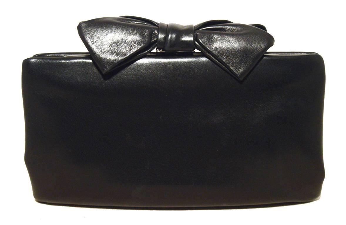 CUTE Chanel black lambskin bow top clutch in excellent condition.  Soft black lambskin leather exterior with a black bow top and delicate CC silver logo on one of the bow loops.  Lifting top closure opens to a black leather lined interior that holds