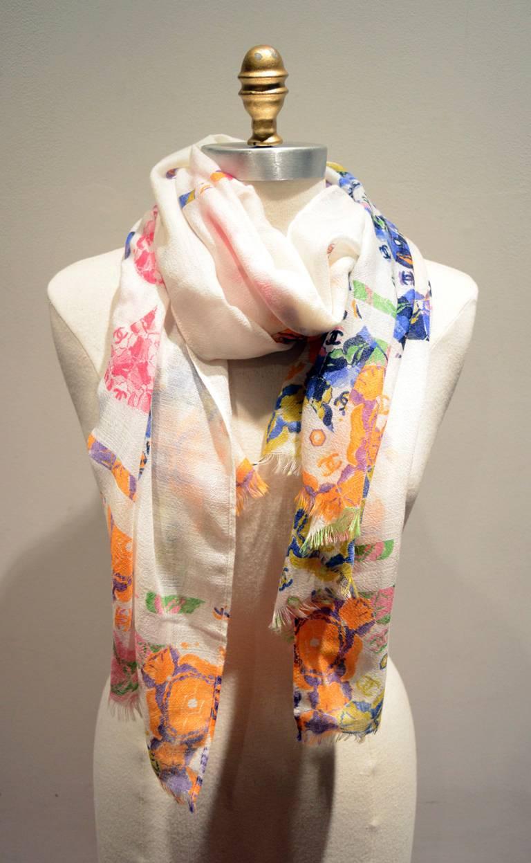 BEAUTIFUL Chanel floral print silk and cashmere shawl scarf in excellent condition.  Multicolor floral print over an ivory background in long rectangle shape.  Original tag attached. 91% cashmere 9% silk. Rolled hem on 2 sides, unfinished frayed hem